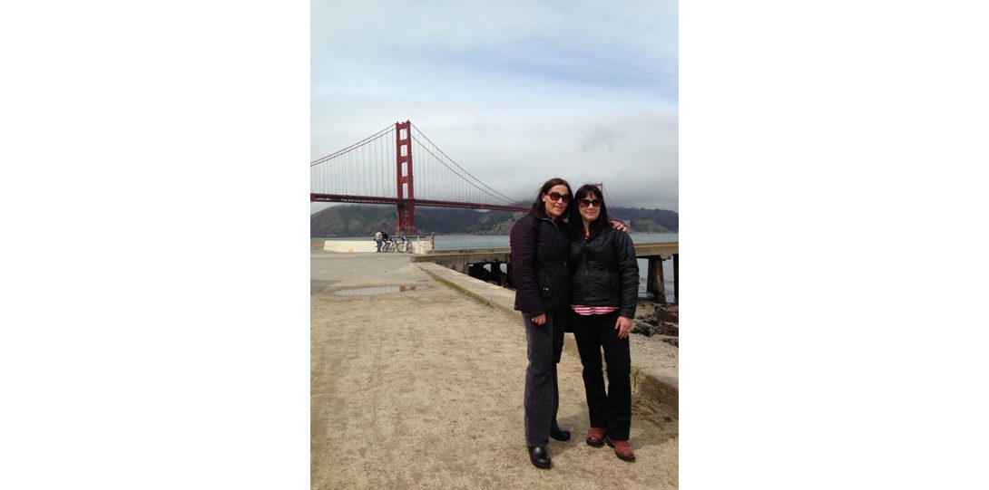 two people standing in front of Golden Gate Bridge in the far background
