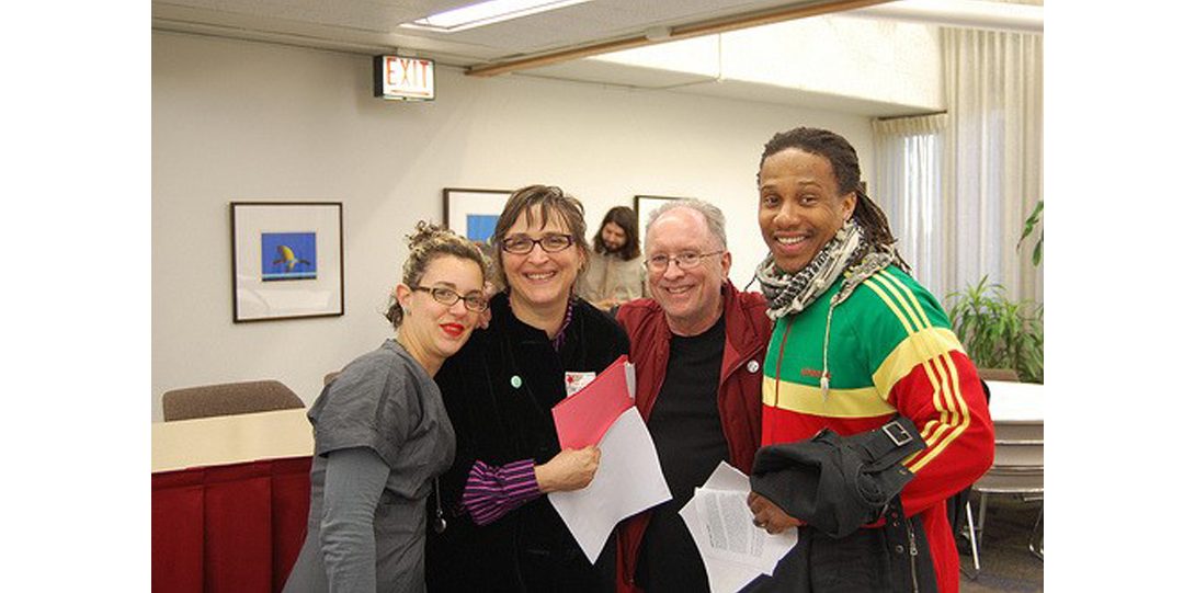 Professor Stovall posing for a photograph with three people all standing to his left.
