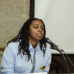 student speaking into microphone while seated