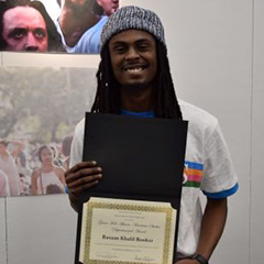 person holding an award certificate posing for photograph