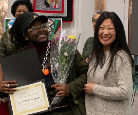 student and faculty posing exchanging award