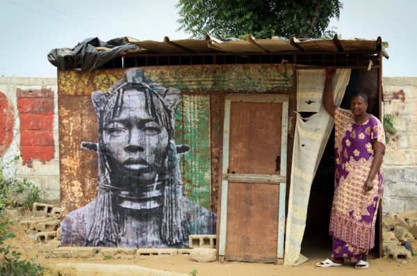 A Woman stands next to a mural