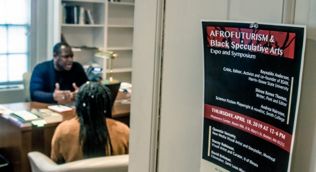 student speaks with a professr in an office