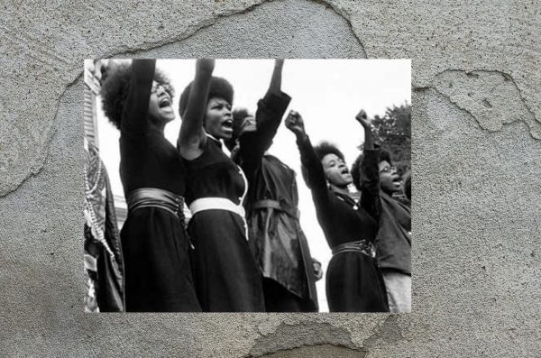 women of the black panthers raise their fists in the air
