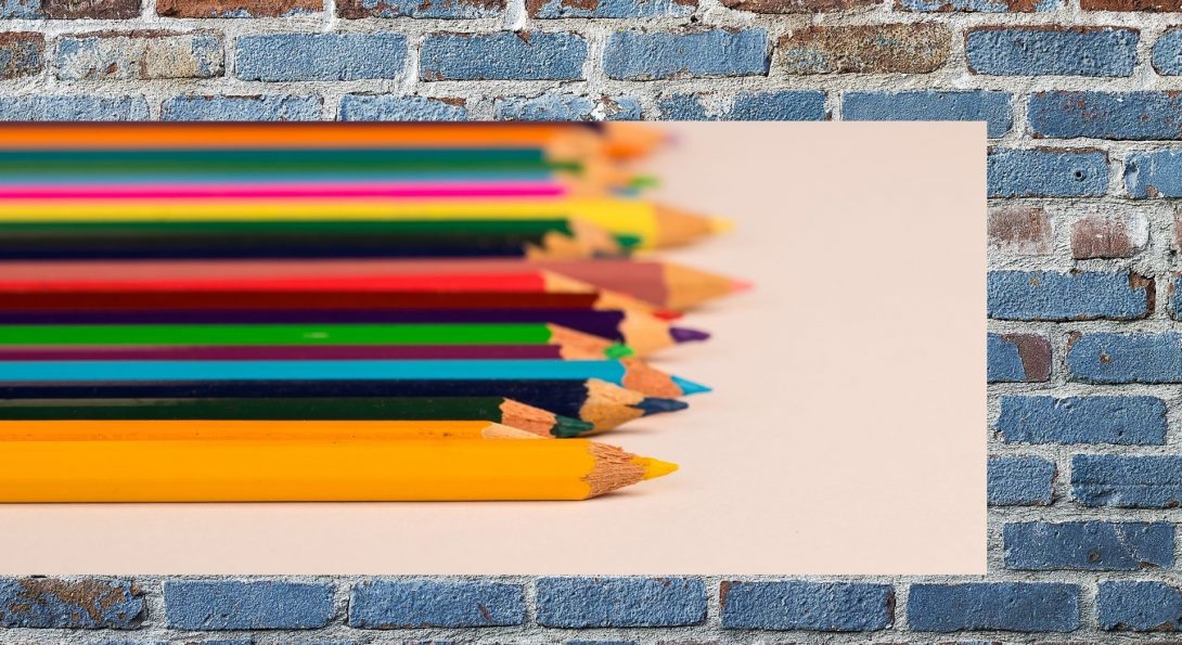 color pencils are superimposed over an image of a blue brick wall