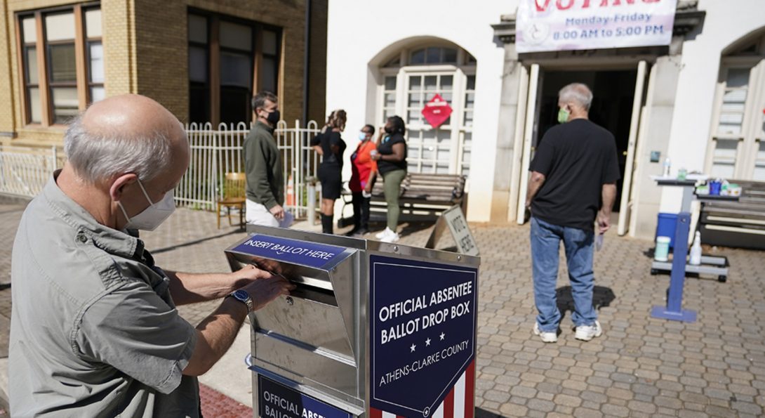 A man drops off a ballot during early voting in Athens, Ga., in October 2020. A new study finds that white boys who grew up with Black neighbors were more likely to register as Democrats 70 years later.