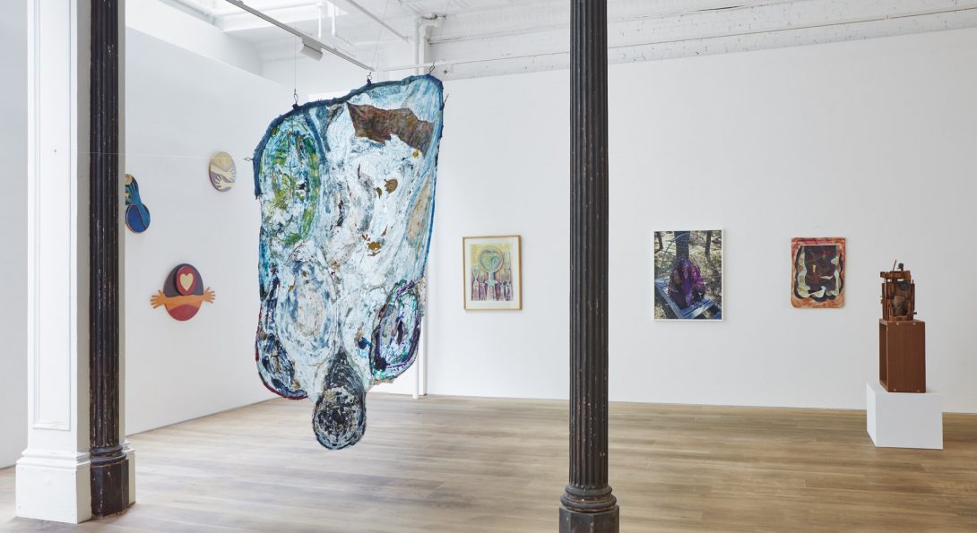 View of “You’ve Come a Long Way, Baby: The Sapphire Show” at Ortuzar Projects. In the foreground, Suzanne Jackson’s amoeba-shaped painting “Rag-to-Wobble” (2020) includes vintage dress hangers.