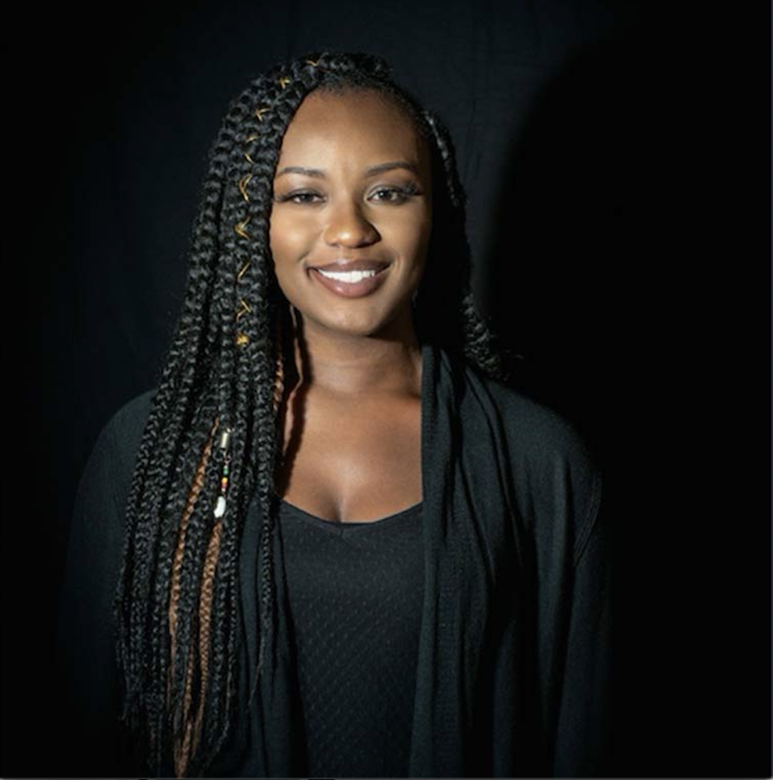 woman wearing a black shirt and jacket smiling at the camera