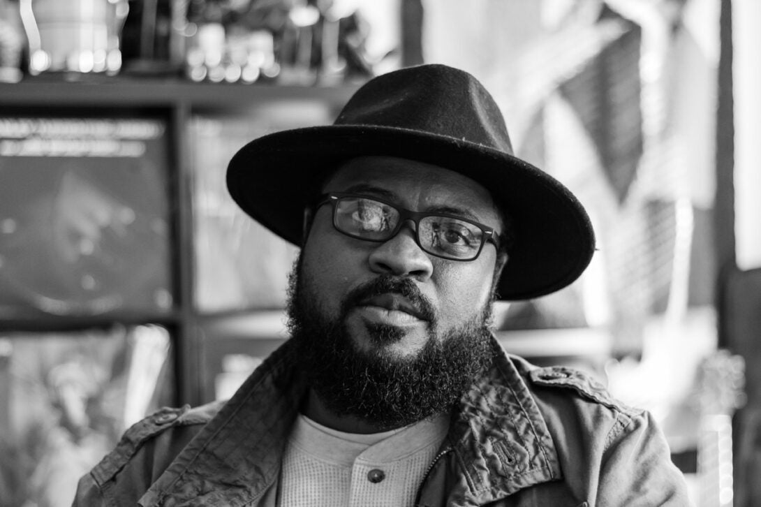 black and white photo. person wearing a hat and glasses looking at the camera