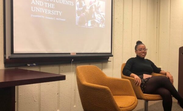 person smiling and sitting in front of a projector