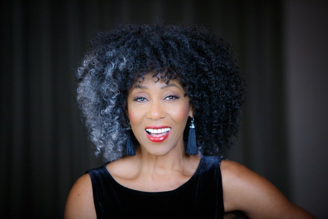 woman with curly hair smiling at camera