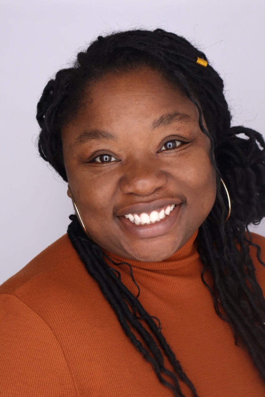 woman with black braids smiling at camera